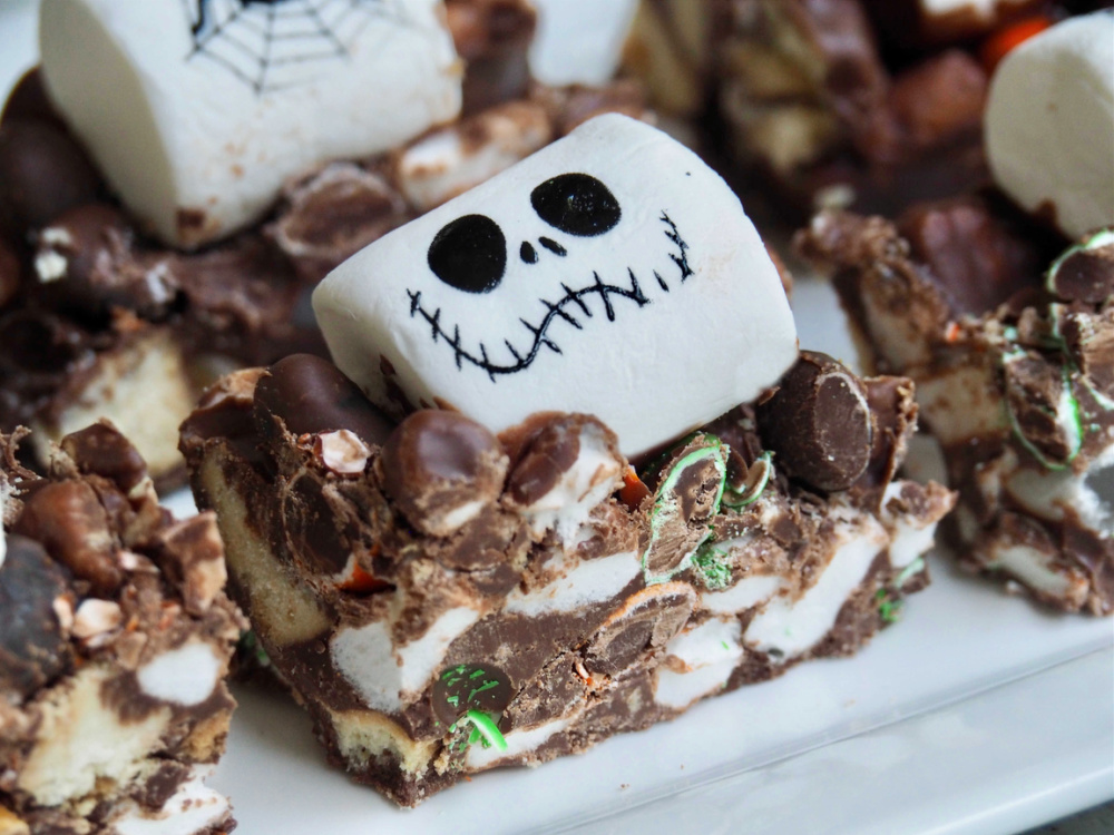 square of halloween rocky road topped with a large white marshmallow decorated with a skull face