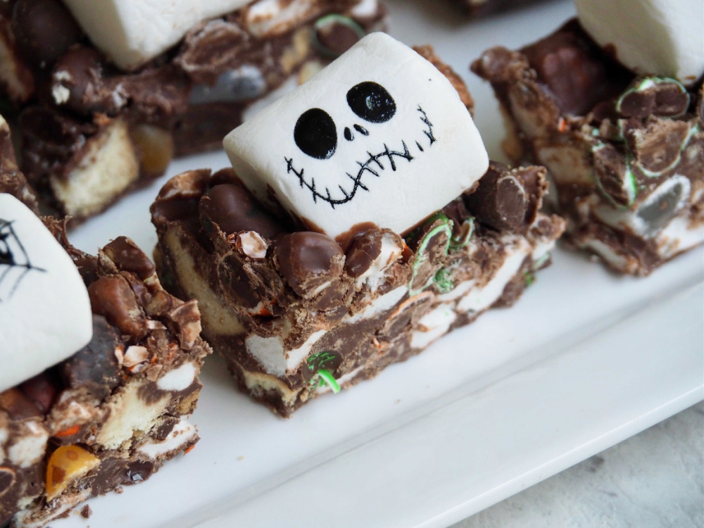 square of halloween rocky road topped with a white marshmallow decorated with a skull face