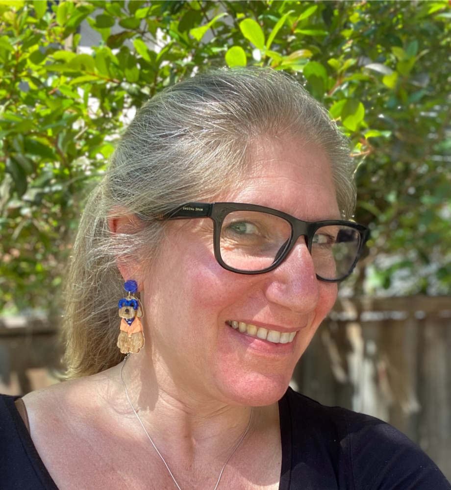 woman with blonde ponytail and black glasses wearing acrylic cavoodle earrings