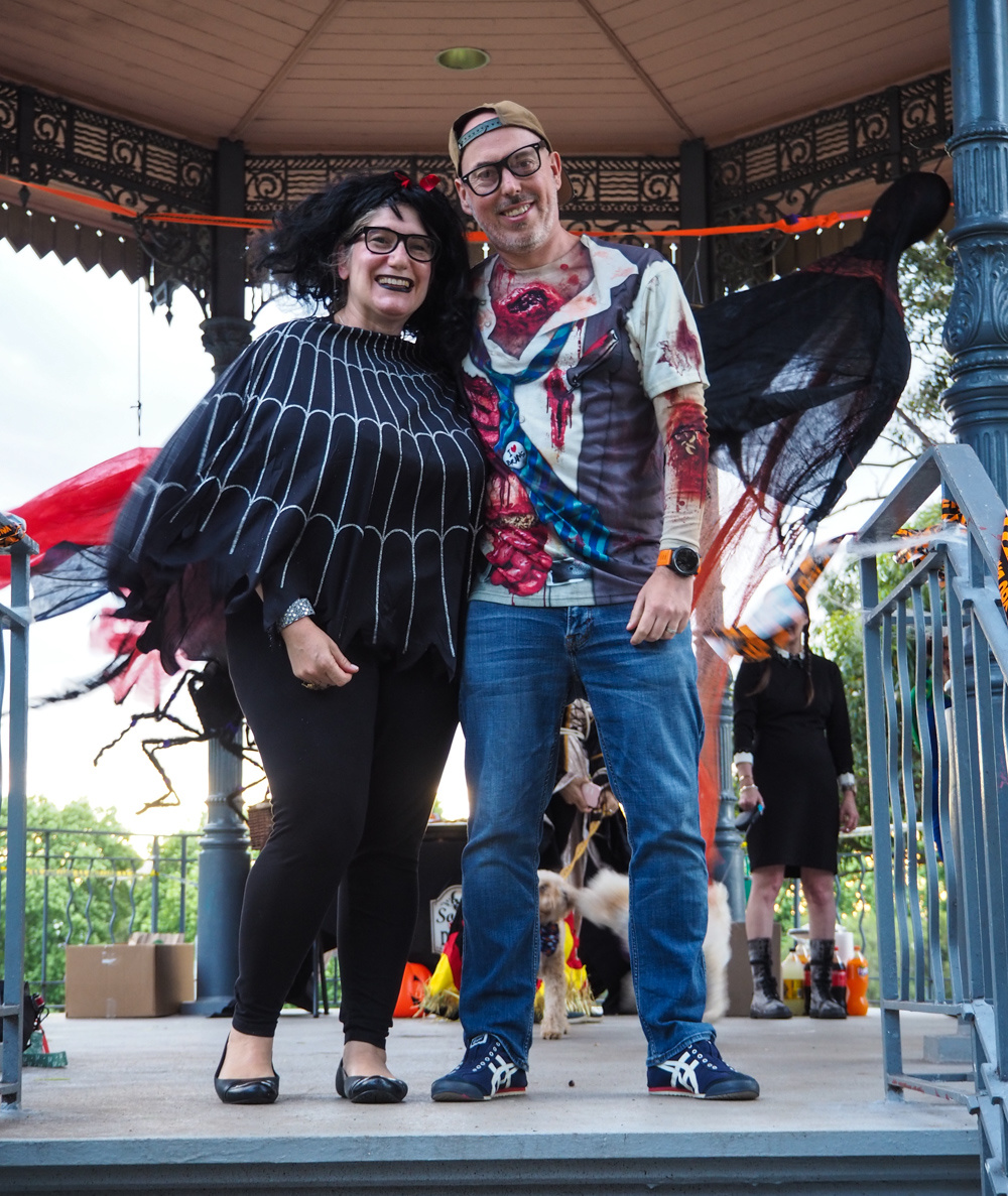 woman wearing spider poncho and man wearing zombie killer tee standing on a rotunda