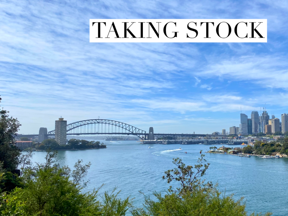 sydney harbour with bridge in background and treetops in foreground