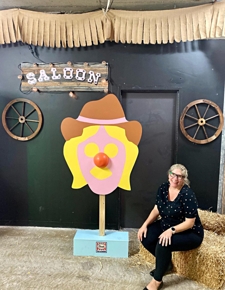 woman sitting on hay bale next to giant bubble o bill