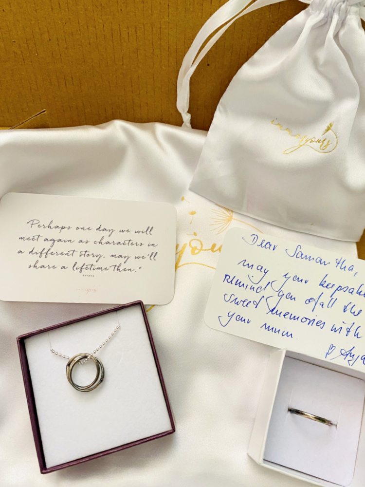a pendant and a ring in boxes with a handwritten card and white silk pouch
