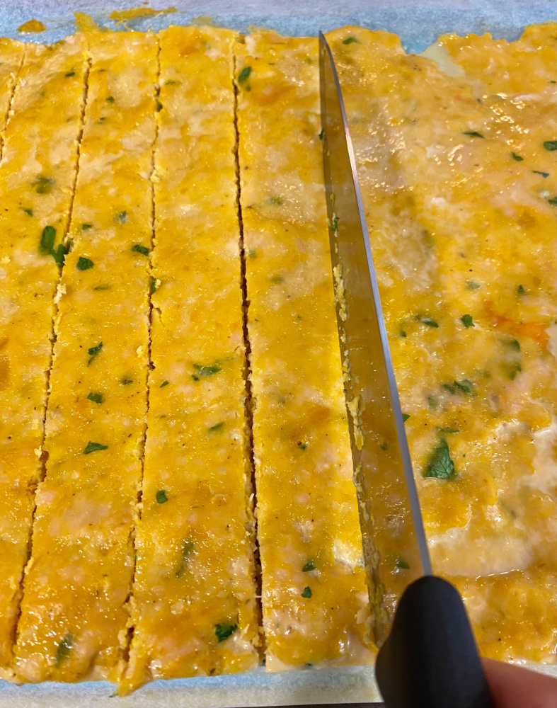 large knife cutting baked turkey mince into treats