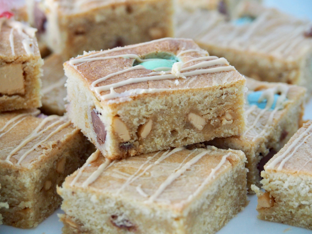 close up of easter caramilk blondies baked with mini eggs and caramilk chunks inside