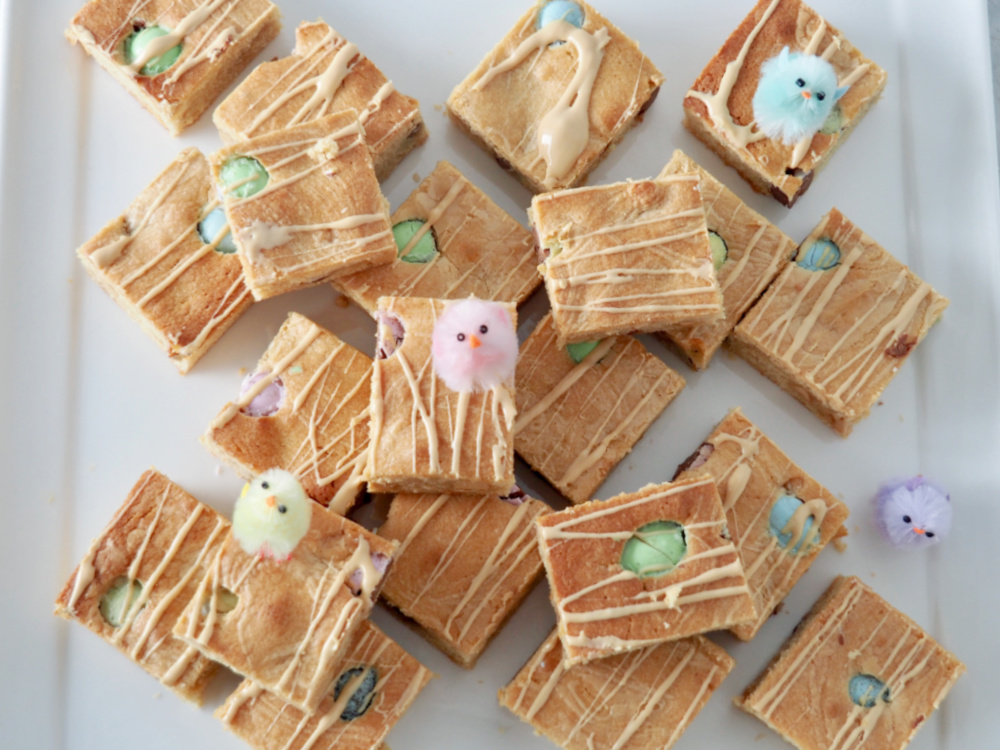 looking down at a plate of easter caramilk blondies with three decorative chicks sitting on top