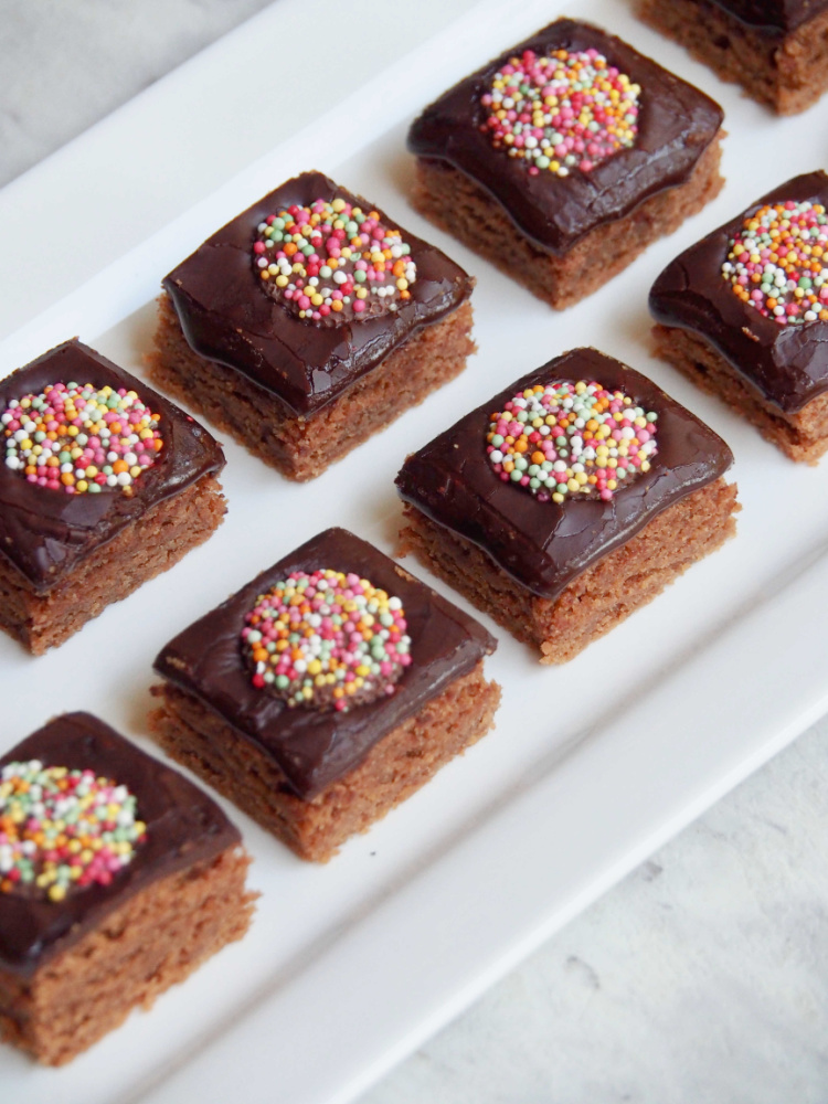 melt and mix weetbix slice cut into individual square on white rectangular serving plate