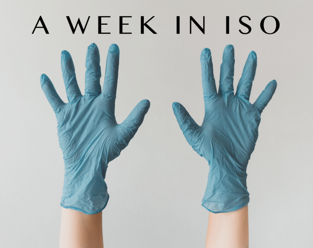 two upstretched hands wearing blue rubber gloves and the title says a week in iso