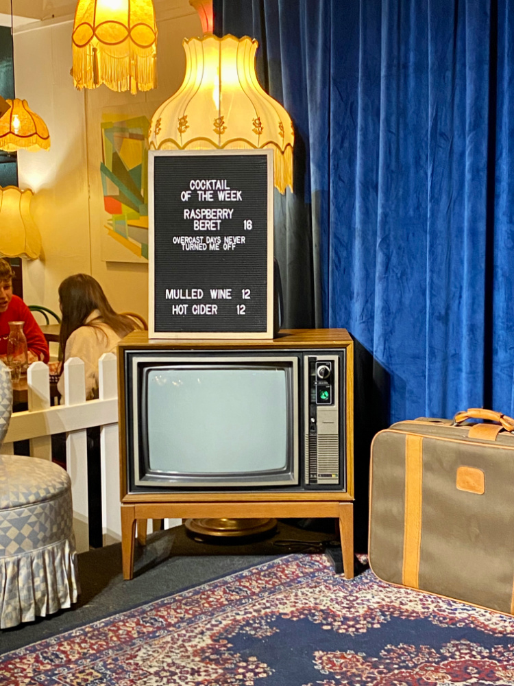 retro style tv with an old fashioned lamp behind and an old suitcase next to it