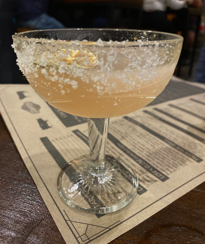 margarita in an crystal style coupe glass with salt around the rim