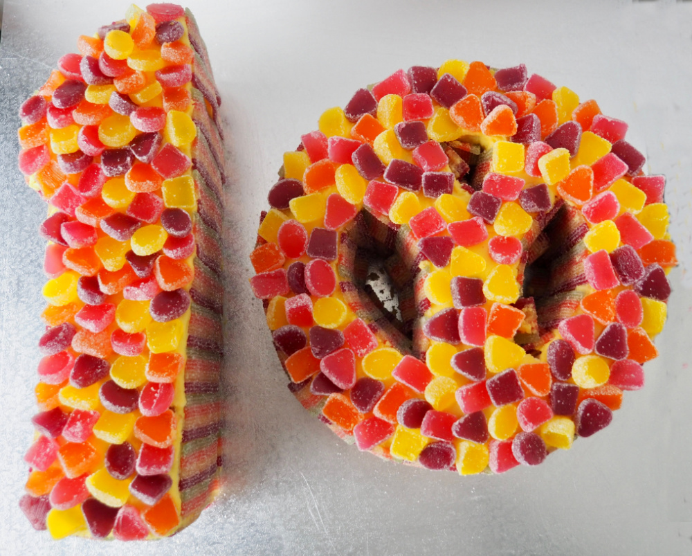 2 cakes in the shape of a 1 and a 0 covered in jubes and placed on a large square silver cake board