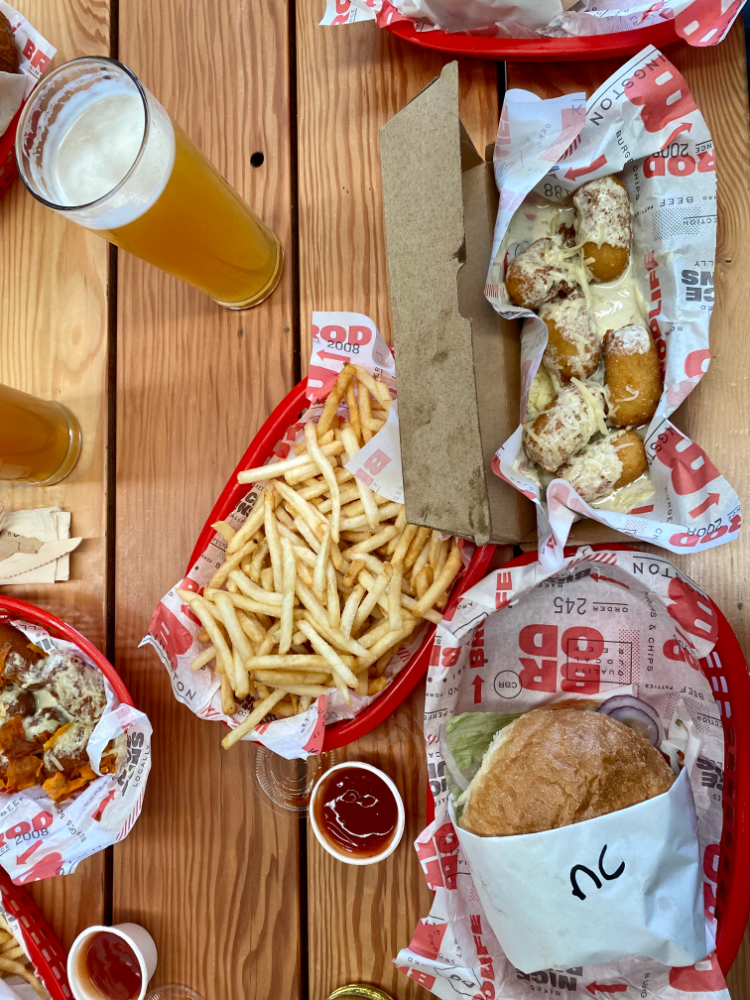 looking down on a table with burgers fries and beer