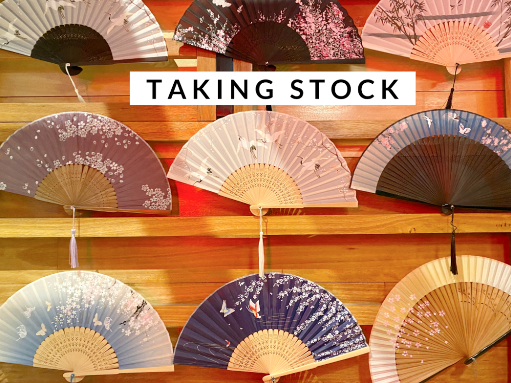 Japanese style fans in rows against a wooden backgroun