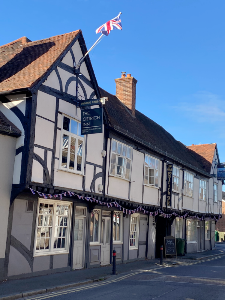 looking side on to a 15th century pub. A sign outside says The Ostrich Inn.