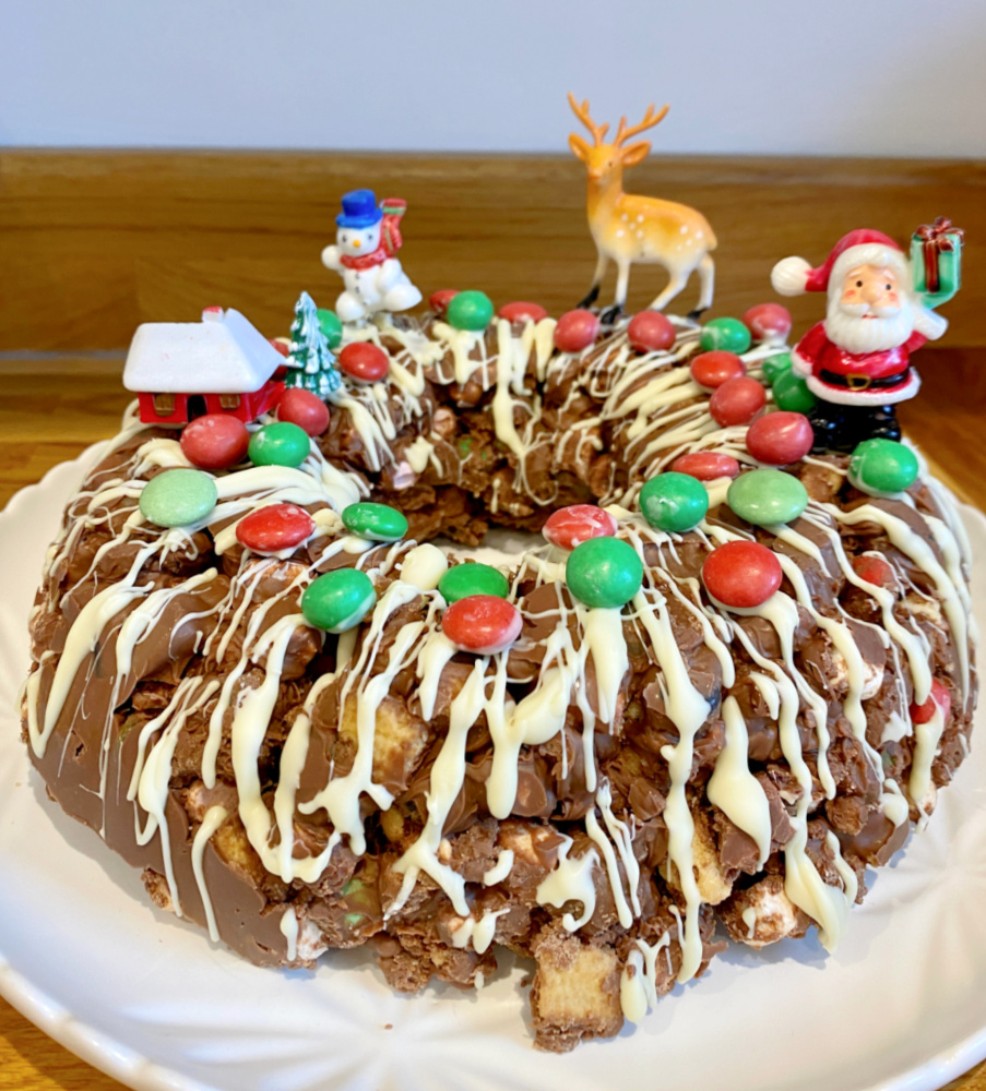 a milk chocolate rocky road wreath drizzled with white chocolate and topped with red and green M and Ms