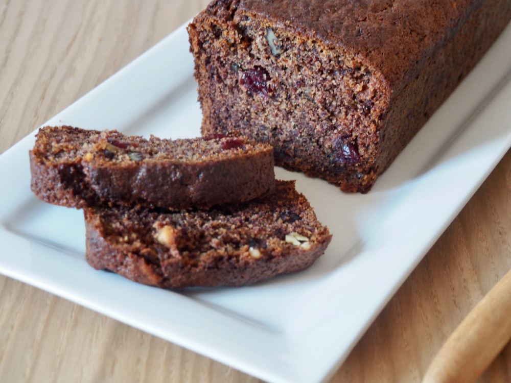 persimmon, cranberry and walnut loaf on white serving dish