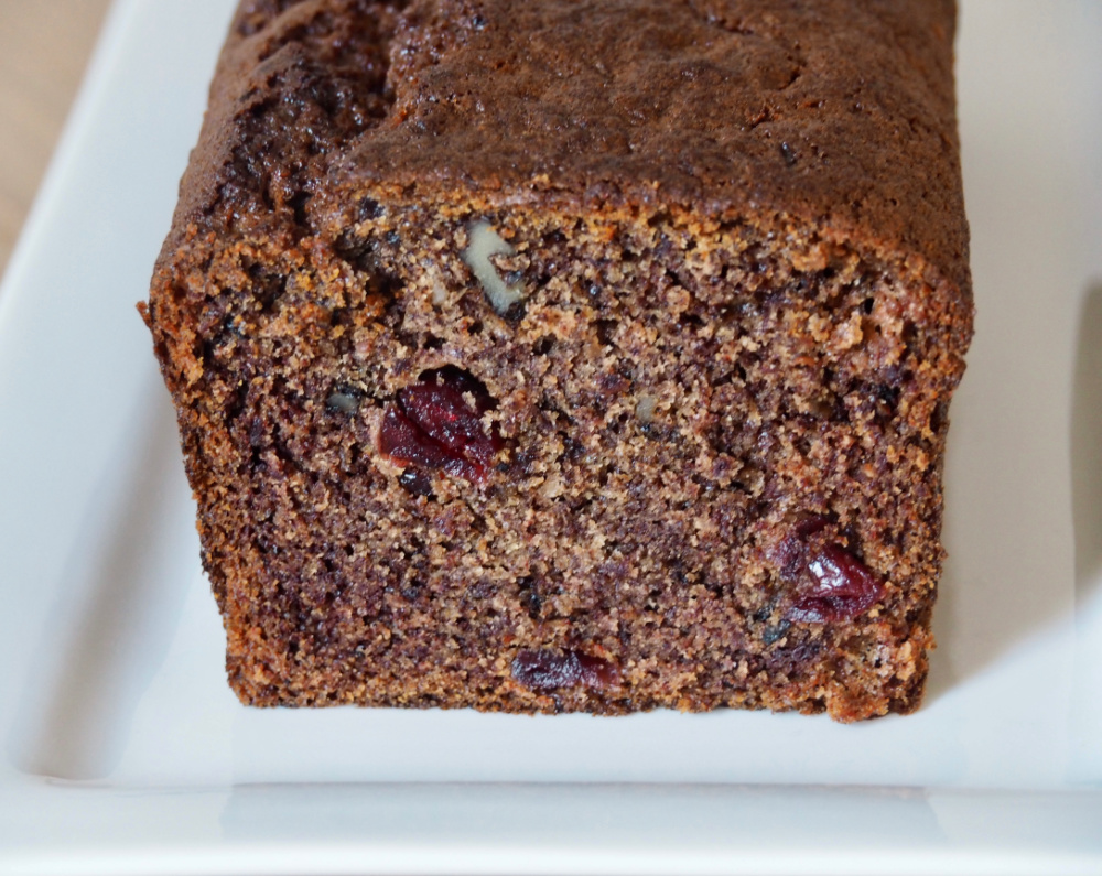 close up of cut persimmon, cranberry and walnut loaf