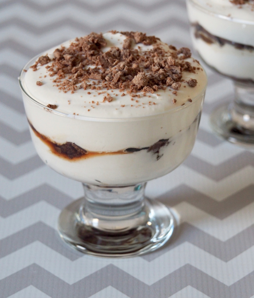 sundae glass filled with tiramisu stye layered dessert with chocolate flake crumbled on top