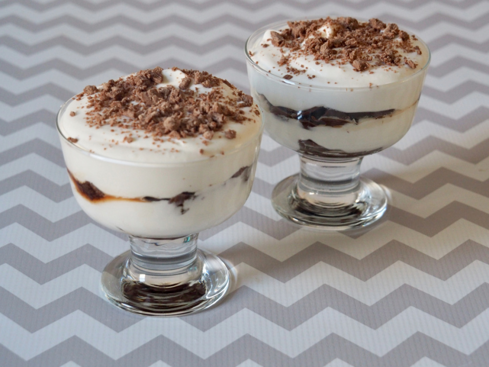 2 sundae glasses of layered tiramisu style dessert with choc flake crumbled on top