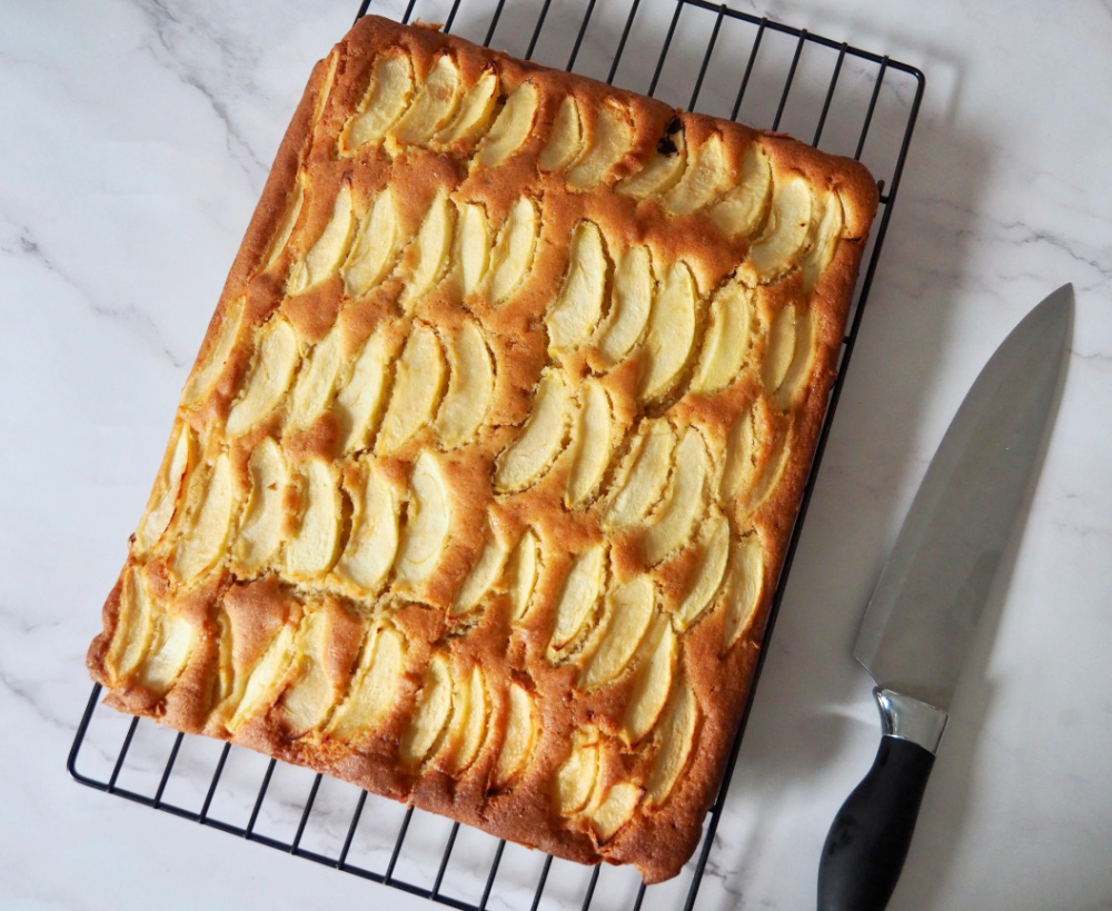 looking down on apple traybake on a cooling rack with a knife next to it