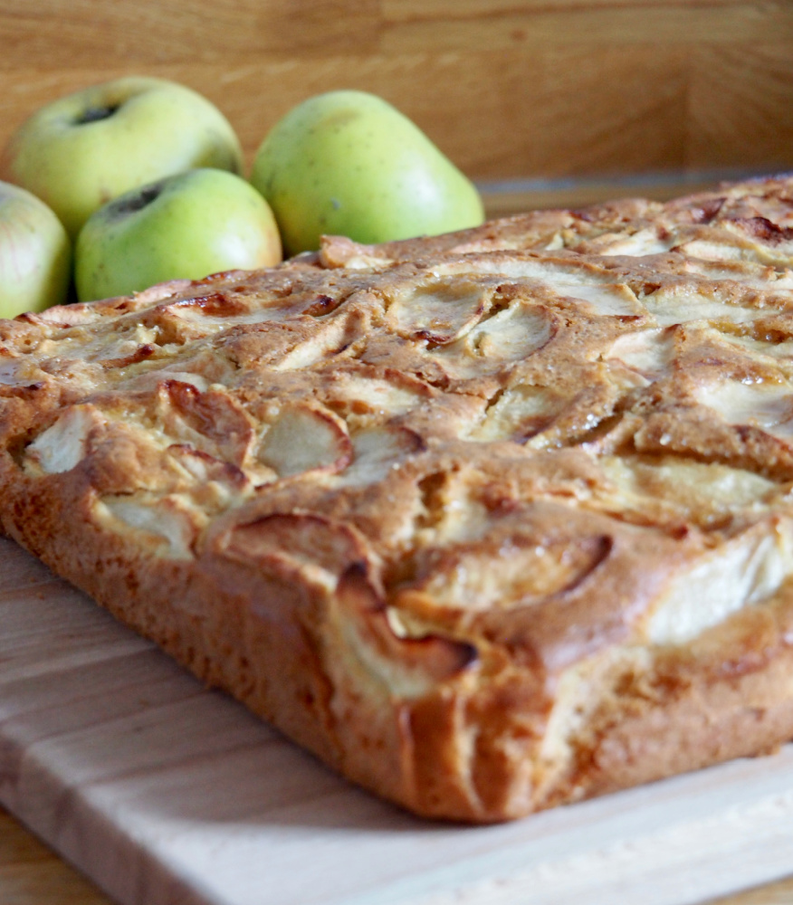 apple traybake on wooden chopping board with green apples in background