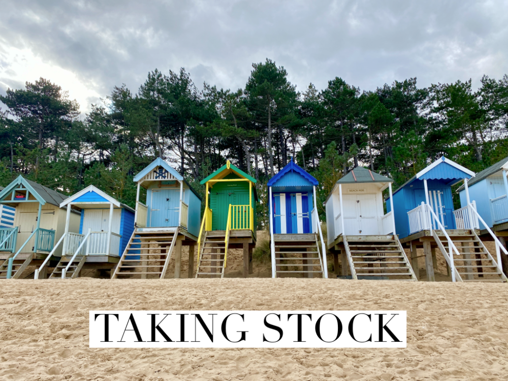 row of beach huts with sand in the foreground