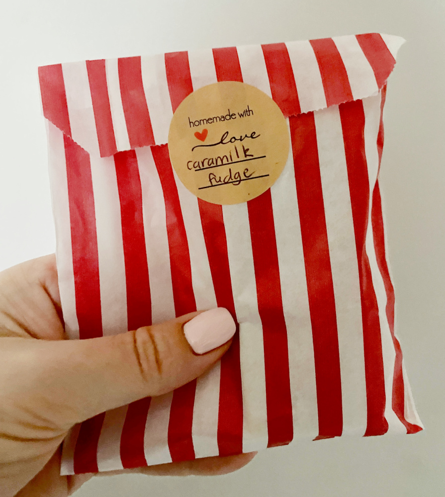 hand holding up small red and white striped candy bag