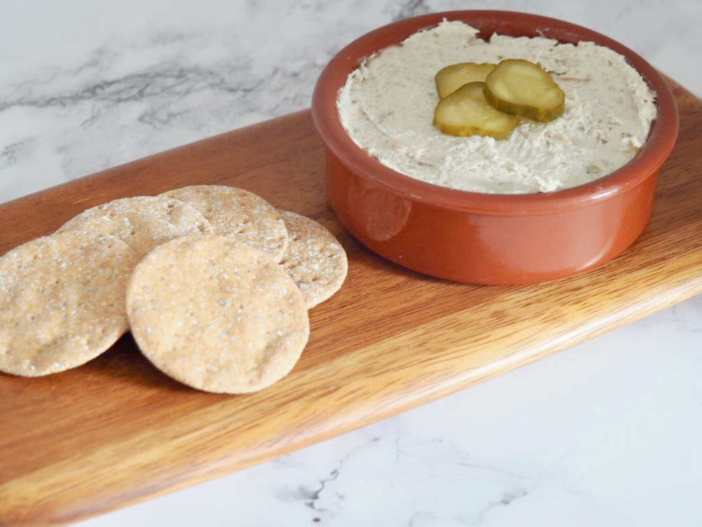 a small bowl of smoked mackerel dip and crackers served on a small serving board