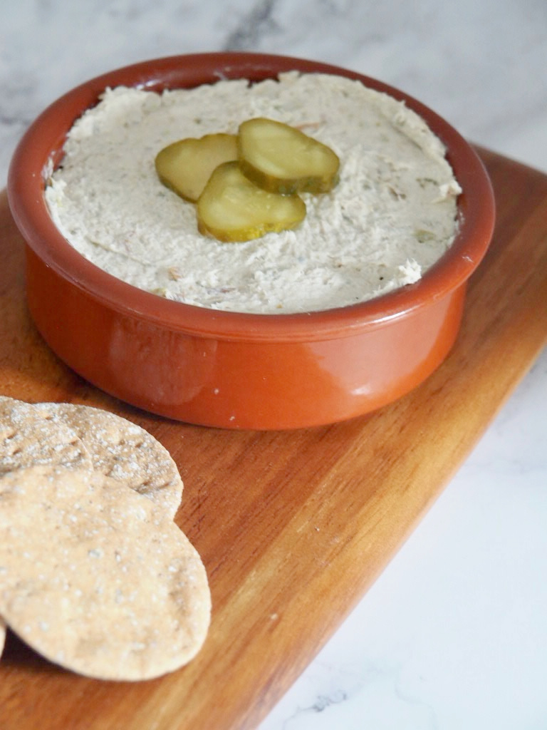 bowl of smoked mackerel dip with crackers on a small serving board