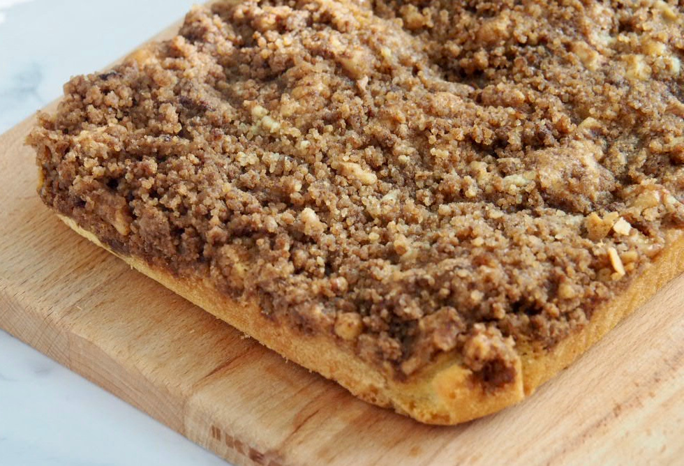 sponge topped with crunchy walnut topping on wooden board