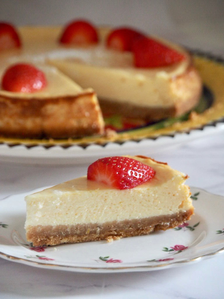 slice of lemon cheesecake  with remaining cake in the background