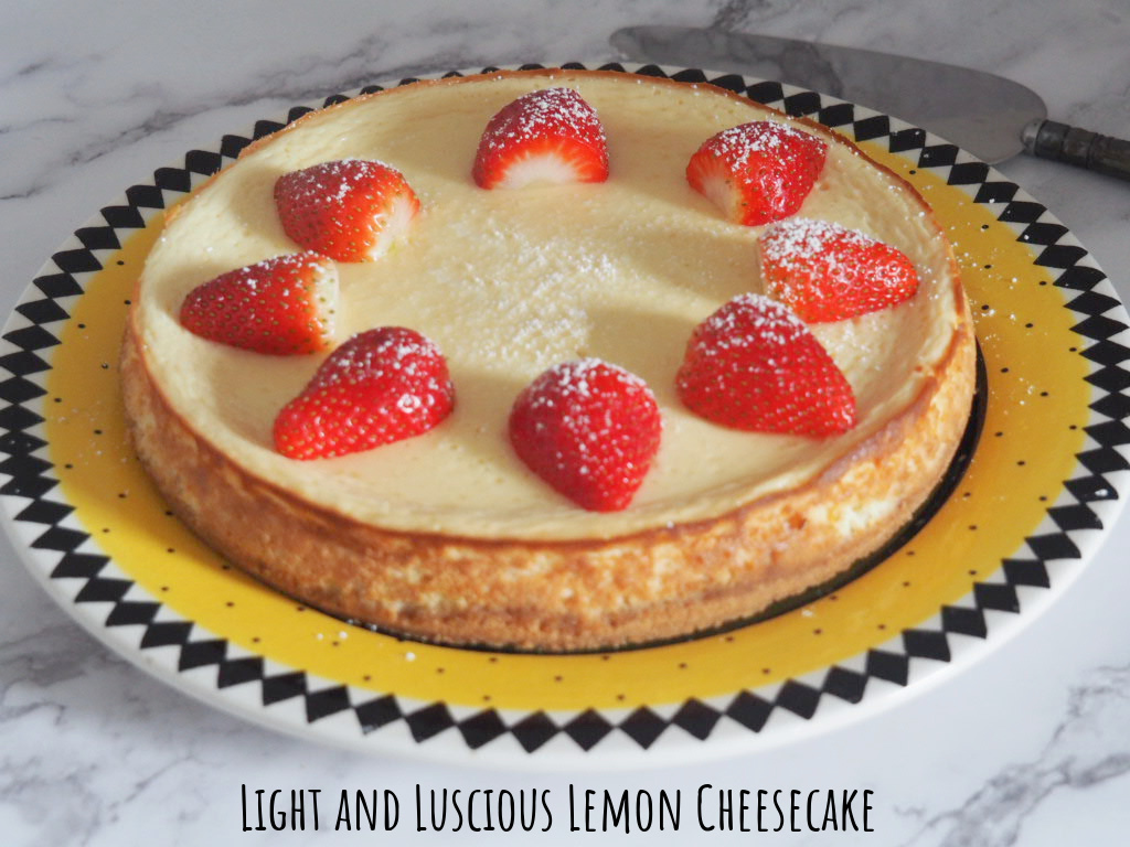 cheesecake on a round yellow plate decorated with halved strawberries