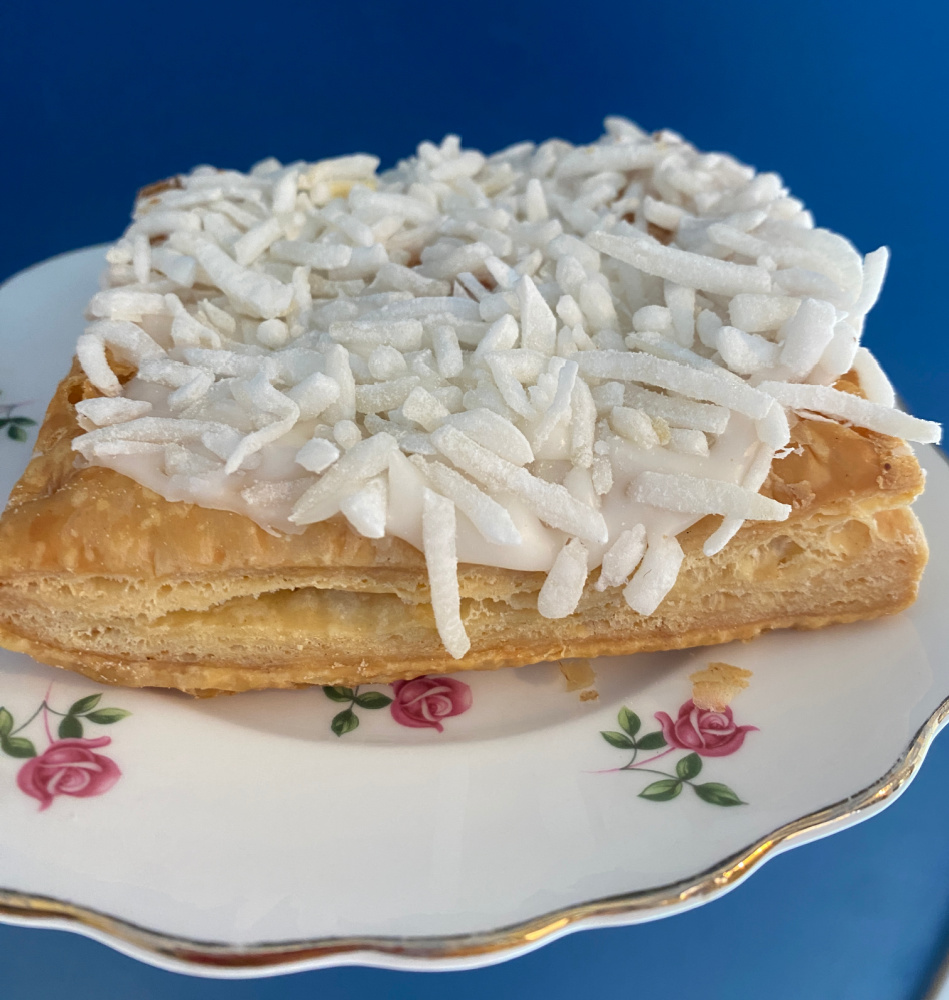 A London cheesecake - a square of puff pastry topped with white icing and coconut strands