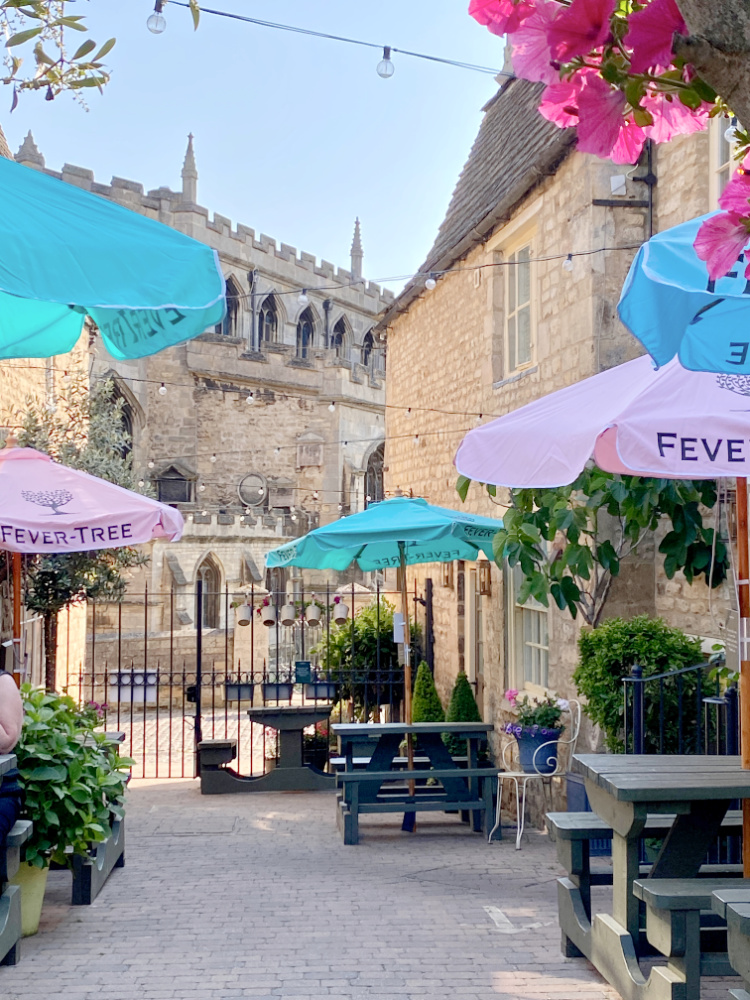 looking through a beer garden with colourful umbrellas with a historic church in the background