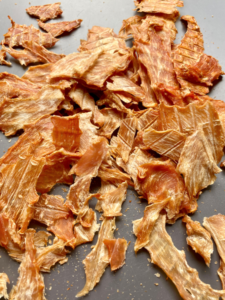 oven blasted chicken jerky on a black board