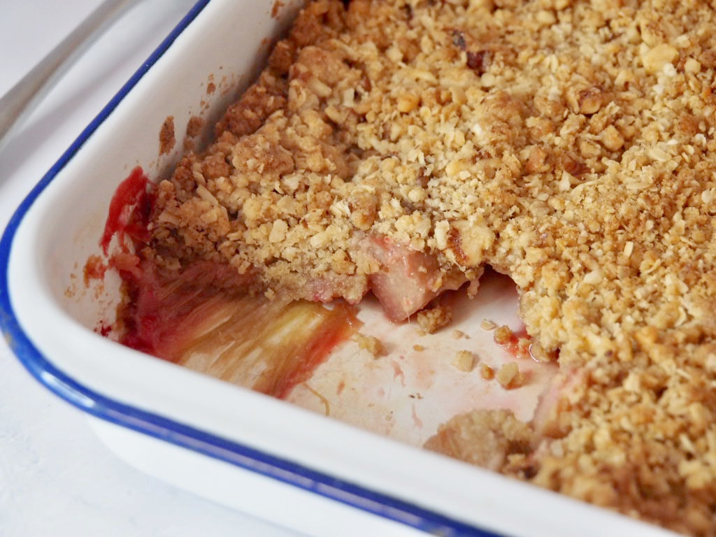 a tray of rhubarb crumble with some removed