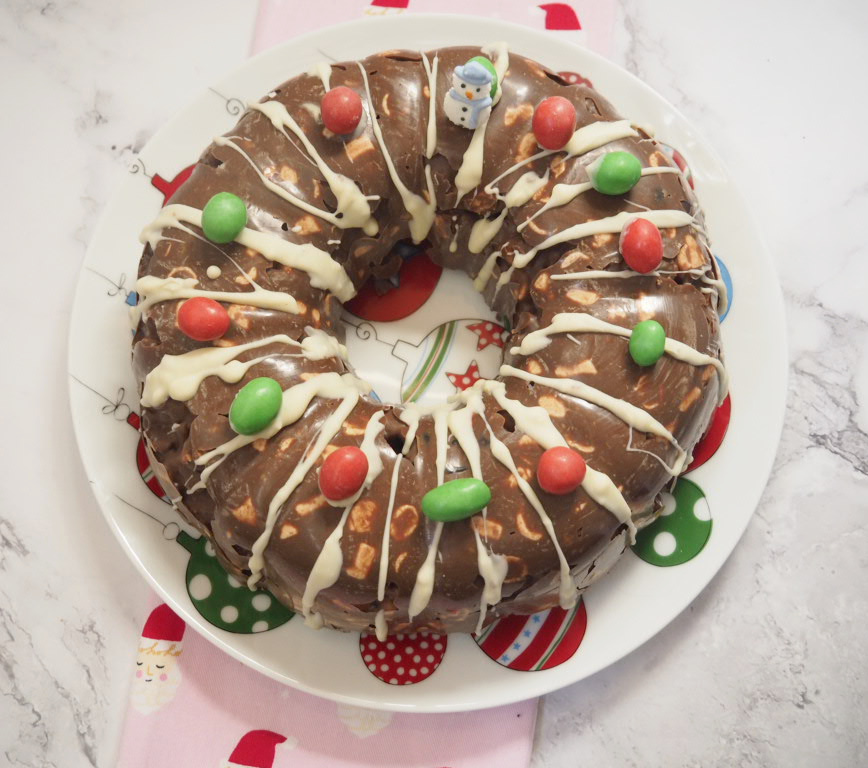 looking down on a rocky road wreath. It's drizzled with white chocolate and decorated with red and green M and Ms 