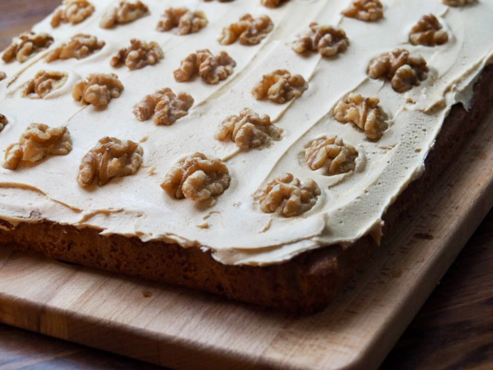 corner of coffee traybake - the sponge is topped with fudge icing and walnuts