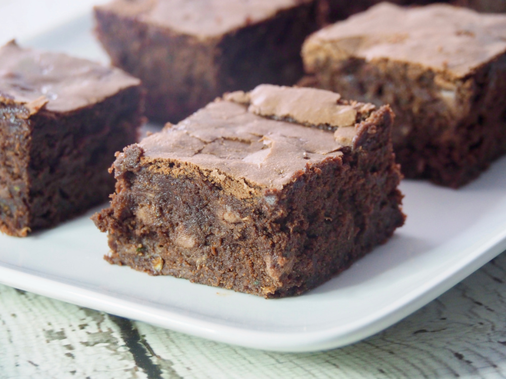 close up of fudgy zucchini brownie on a long white serving dish